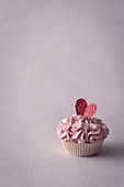 Cupcake mit rosa Frosting zum Valentinstag