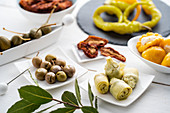 Different antipasti: olives, artichokes, caper berries, chili peppers