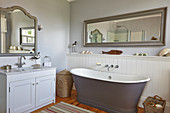 Free-standing bathtub, vanity and mirror in the bathroom