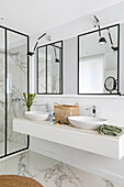 Elegant bathroom with washstand, twin sinks, wall mirrors and marble floor