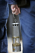 Person holding a gas lamp at a commemoration