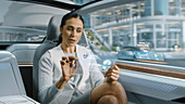 Woman using a tablet in an autonomous car