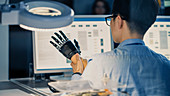 Prosthetic robot arm being tested by an engineer