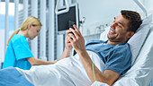 Recovering patient using a smartphone lying in bed
