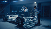 Automobile engineers working on an electric car prototype