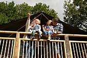 Happy family at a cabin railing