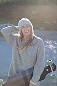 Happy young woman with skateboard