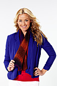 A blonde woman wearing a blue blazer with a scarf