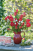 Frühlingsstrauß aus roten Tulpen, Zierkirsche und Traubenkirsche