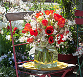 Spring bouquet of red tulips, branches of shadbush and cornelian cherry and lenten roses