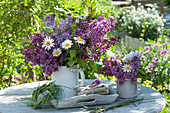 Bouquets of lilacs and daisies in enameled pots