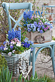 Basket and wooden box with horned violets, grape hyacinths, hyacinths, daisies, and forget-me-nots, small wreaths of grasses and willow catkins as decoration