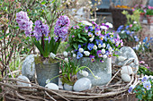 Easter decoration with hyacinths, horned violets, grape hyacinths, Tausendschon Rose, and forget-me-not, decorated in a wreath of clematis vines with Easter eggs in various sizes
