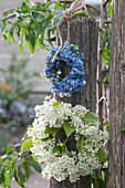 Forget-me-not and bird cherry wreaths hanging from posts
