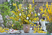 Easter bouquet made of flowering branches of forsythia, decorated with Easter eggs