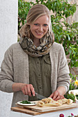 Osterterrasse: Frau schneidet Lachsröllchen fürs Osterfrühstück