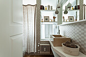 Waschtisch mit Stein-Aufsatzbecken und beigefarbene Wandfliesen im Bad mit satiniertem Glas