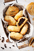 Freshly baked Eccles cakes in a rustic tin One has been cut open