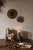 DIY paper rosettes over wooden table with wrapped Christmas gifts and lantern