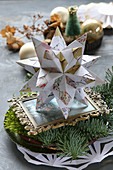 Table arrangement with a Bascetta star hand-folded from origami paper and moss on a plate