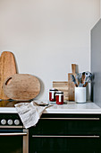 Marmeladengläser mit DIY-Etikett, Küchenwerkzeuge und Holzbretter auf Küchenarbeitsplatte