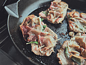 Saltimbocca being fried in a pan