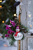 Posy and clown snowman hung on door handle as Christmas tree decorations