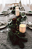 DIY garland of pine and fir branches with various cones on Christmas table