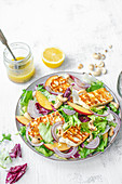 Salad with grilled halloumi cheese, nectarines, onions and cashewnuts