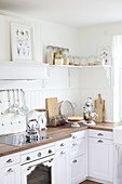 Küchenecke mit Holzarbeitsplatte und weißen Fronten