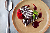 Chocolate sponge with chocolate icing, fresh strawberry, chocolate sauce and fresh mint