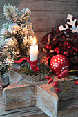 Candles in baking molds on a wooden star, Christmas tree ball, Christmas tree and rose hips