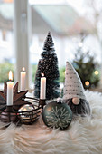 Iron basket as an Advent wreath with Christmas tree balls, zinc star, gnomes and trees