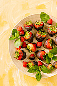 Mit Schokolade überzogene Erdbeeren und Himbeeren