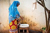 Woman using a tap, Lamu, Kenya