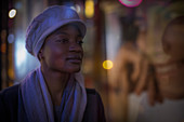 Young woman in hat and scarf at night