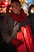 Young woman with Christmas shopping bags in taxi