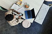 Businessman using smartphone at laptop in an office