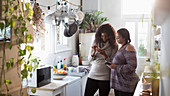 Mother and daughter using smartphones in kitchen