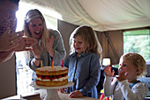 Happy family celebrating birthday with strawberry cake