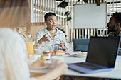 Businesswoman talking with coworkers in office meeting