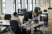 Businesswomen working at computers in open plan office