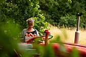 Woman with fresh harvested apples at tractor in orchard