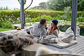 Romantic couple relaxing on luxury hotel patio cushions