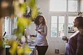 Mother and daughter talking and drinking tea in kitchen