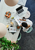 Businesswoman reviewing paperwork at breakfast in office