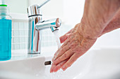 Woman washing hands at bathroom sink