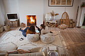 Mother and daughter using digital tablet by fireplace