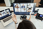 Businesswoman video conferencing with colleagues at screen
