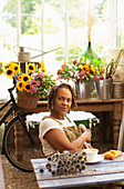 Confident female florist taking coffee break in flower shop